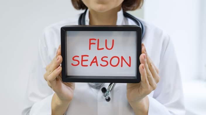 Flu season text in the hands of a female doctor