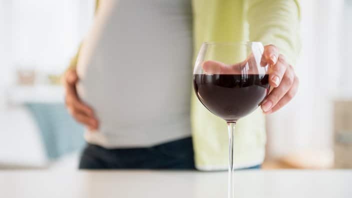 Pregnant woman with glass of red wine