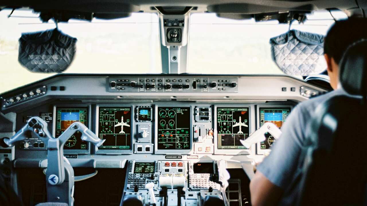 Rear View Of Pilot Sitting In Cockpit