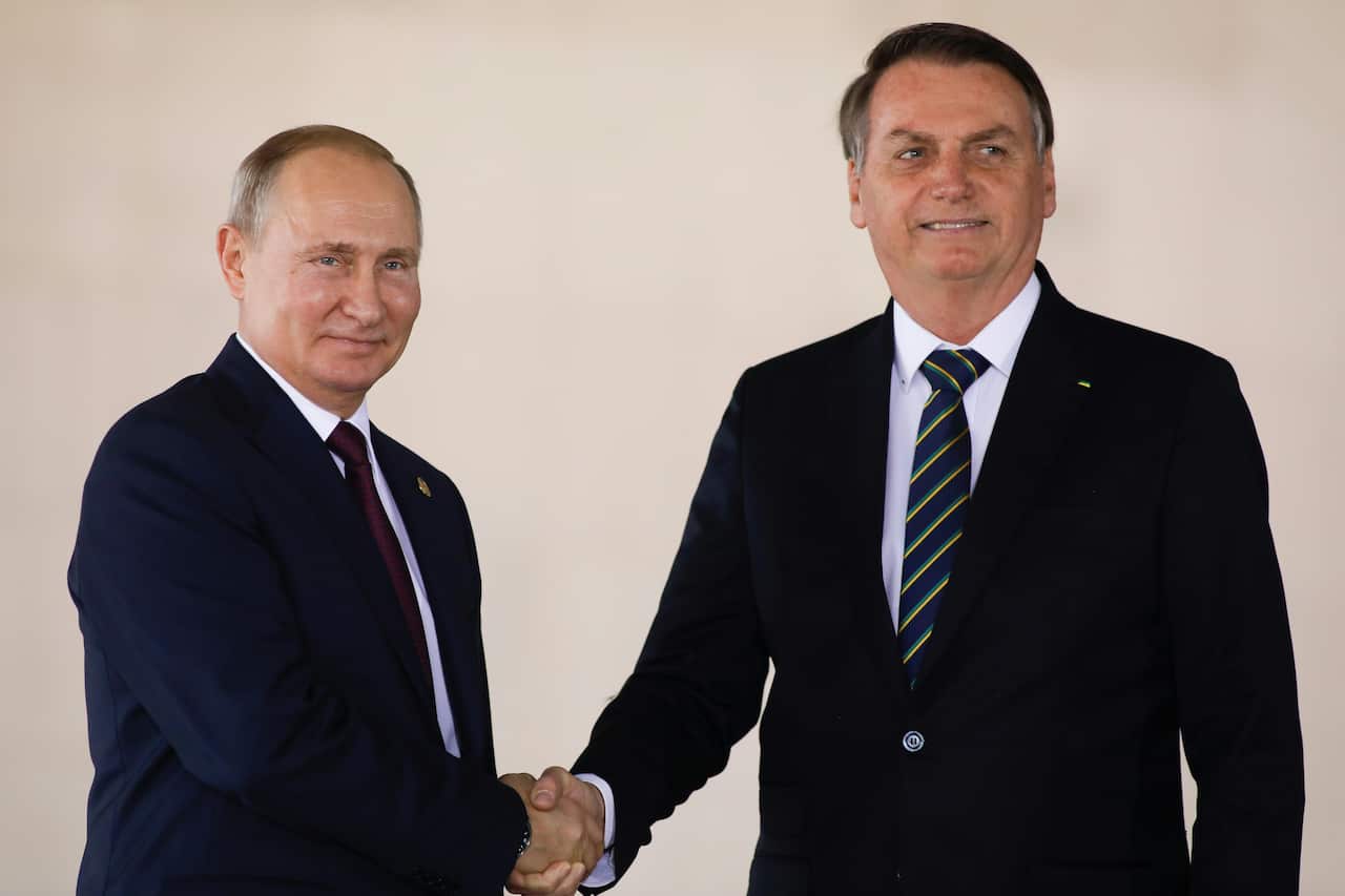 Russia's President Vladimir Putin (L) shakes hands with Brazil's President Jair Bolsonaro