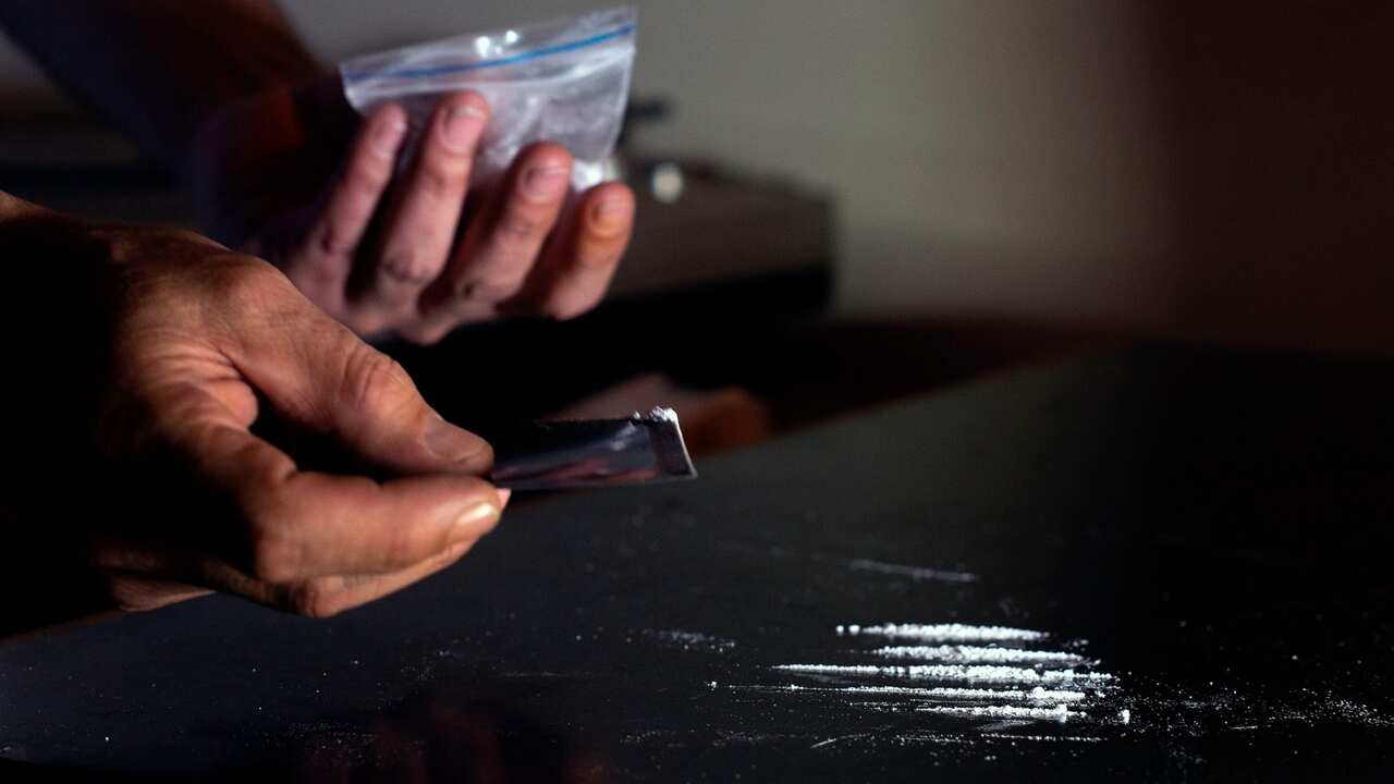 A cocaine consumer prepares the drug to be sniffed, during an interview with AFP in Bogota, on January 29, 2020. - Narcodiseases affect consumers in Colombia, the largest world producer of drug. The loss of nasal septum, depression, coronary, hepatic or n