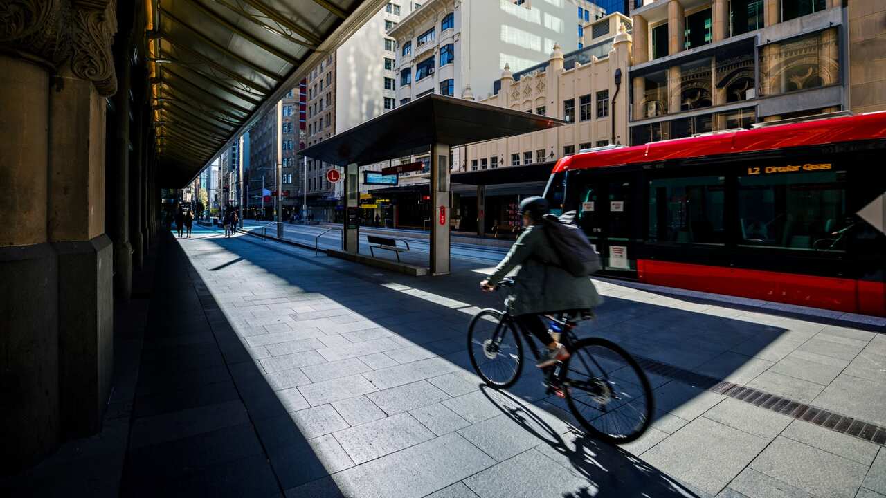 City life with cyclist and red tram, light rail station, Australia - stock photo Queen Victoria Building, George Street, Sydney, NSW, Australia – May 12, 2020