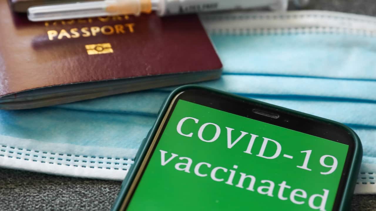 'COVID-19 vaccinated' sign displayed on a phone screen, passports, medical syringes and a face mask are seen in this illustration photo taken in Krakow, Poland on April 28, 2021
