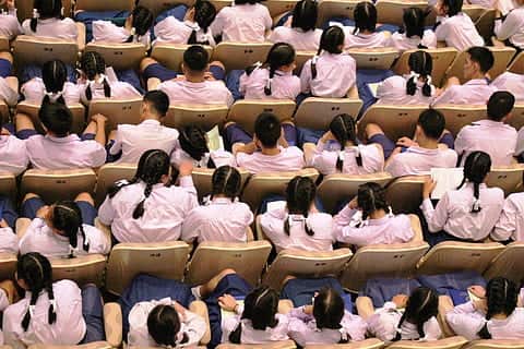HK school children sitting in a school hall.