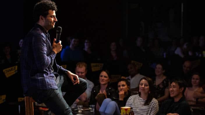 Khaled Khalafalla performing stand-up comedy routine on stage.