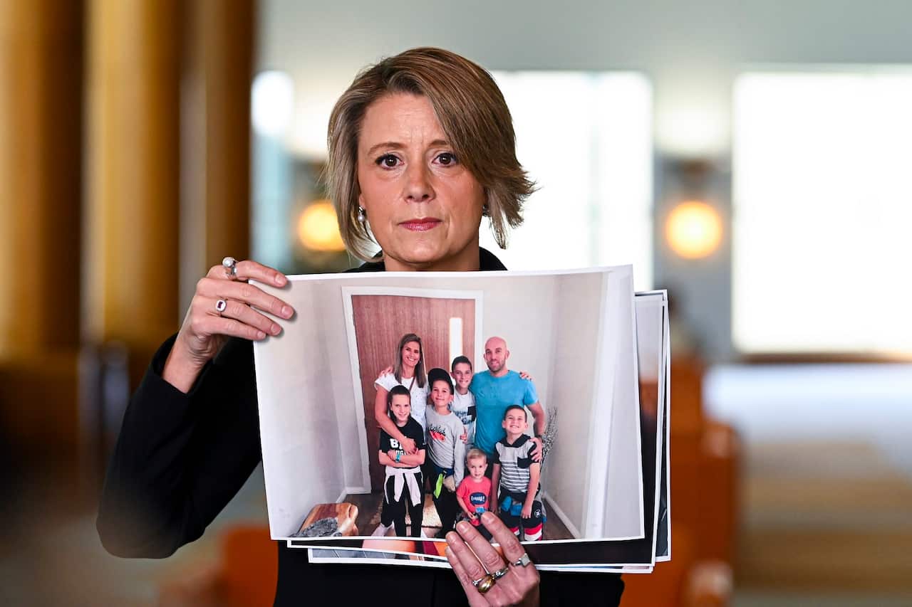 Shadow Immigration Minister Kristina Keneally holds up pictures of stranded Australian citizens during a press conference at Parliament House in Canberra, Thursday, September 24, 2020. (AAP Image/Lukas Coch) NO ARCHIVING