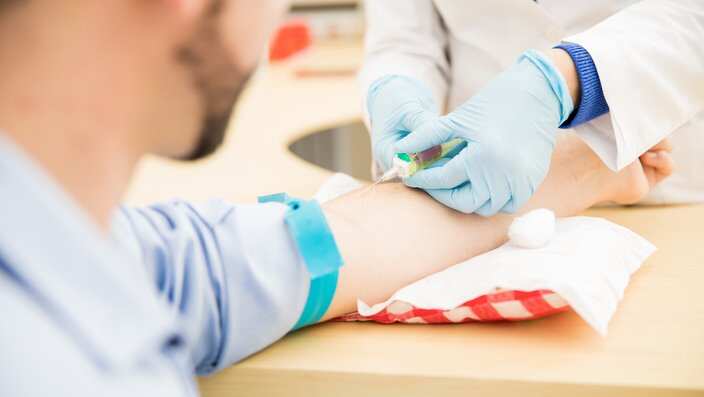 Point of view of a male patient getting blood drawn for a blood test in a clinic