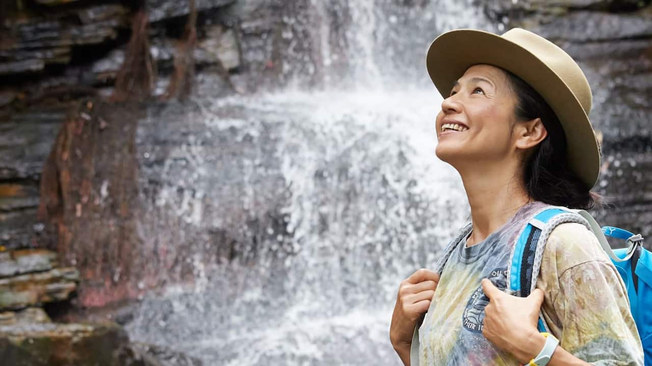 Mayumi Kataoka standing next to a waterfall