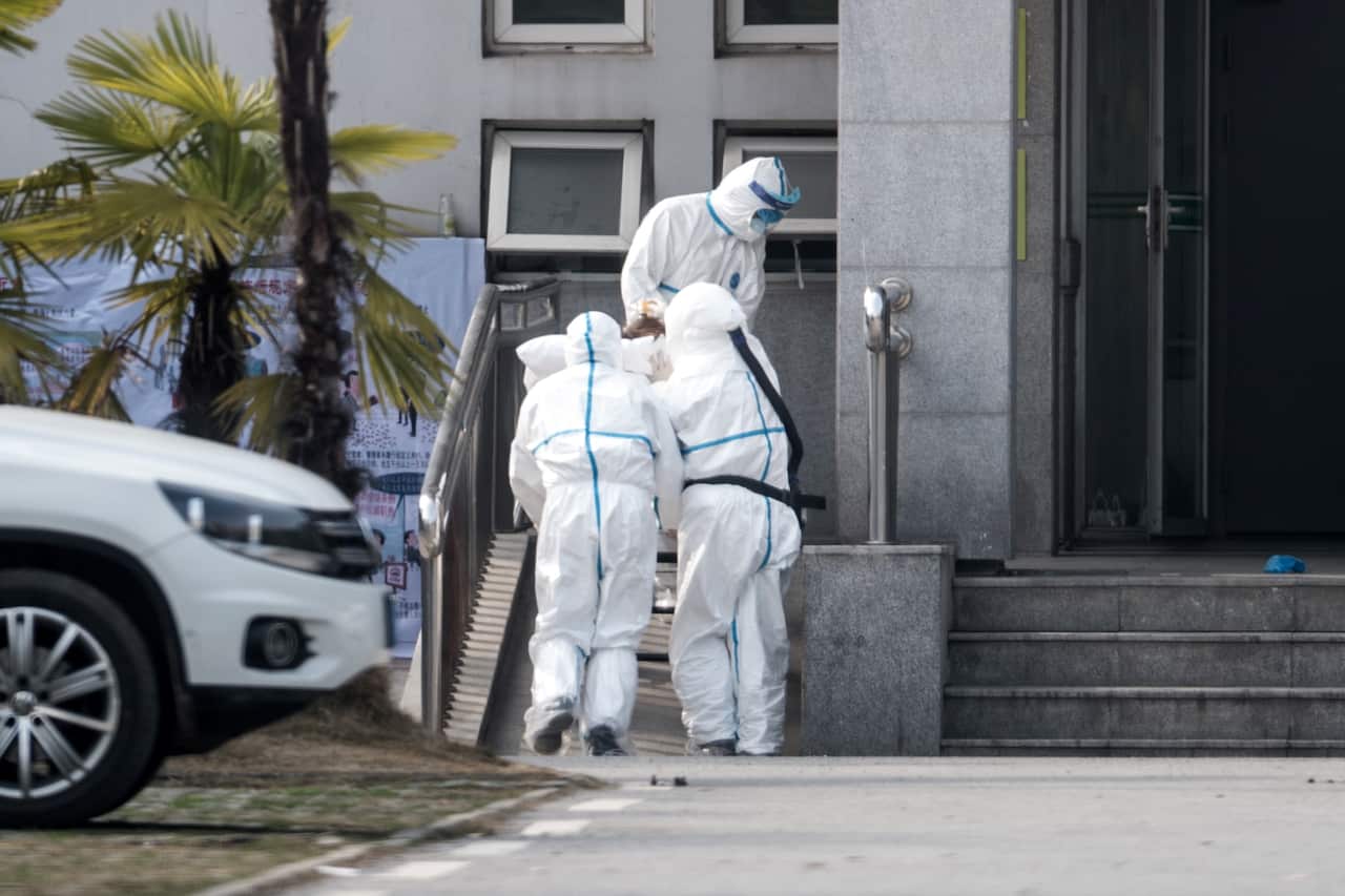 Medical staff carry a patient into the Jinyintan hospital, where patients infected with a new strain of Coronavirus.