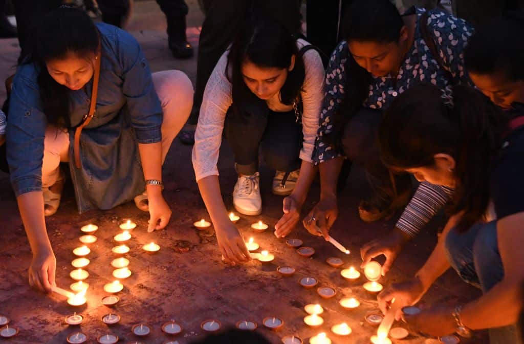 Nepali youth activists light candles during a vigil in memory of the victims of acid attacks in Kathmandu on September 27, 2018.