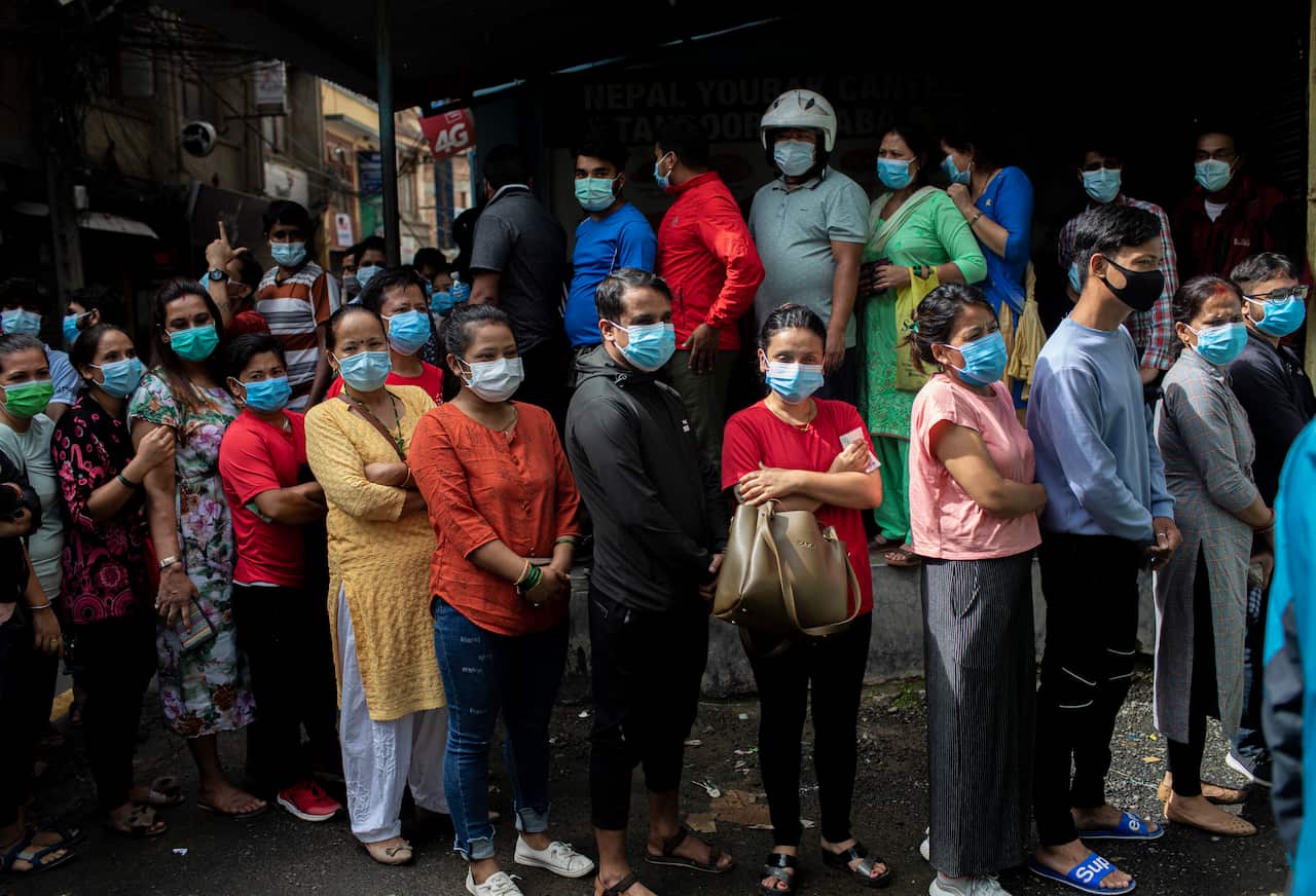 A group of women line up to receive a dose of Shinopharm Vero cell COVID-19 vaccine in Kathmandu, Nepal. 31 July 2021.
