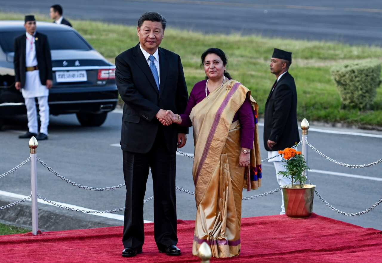 Nepal's President Bidhya Devi Bhandari (R) shakes hands with China's President Xi Jinping (L) at Tribhuvan International Airport in Kathmandu, 12 October 2019.