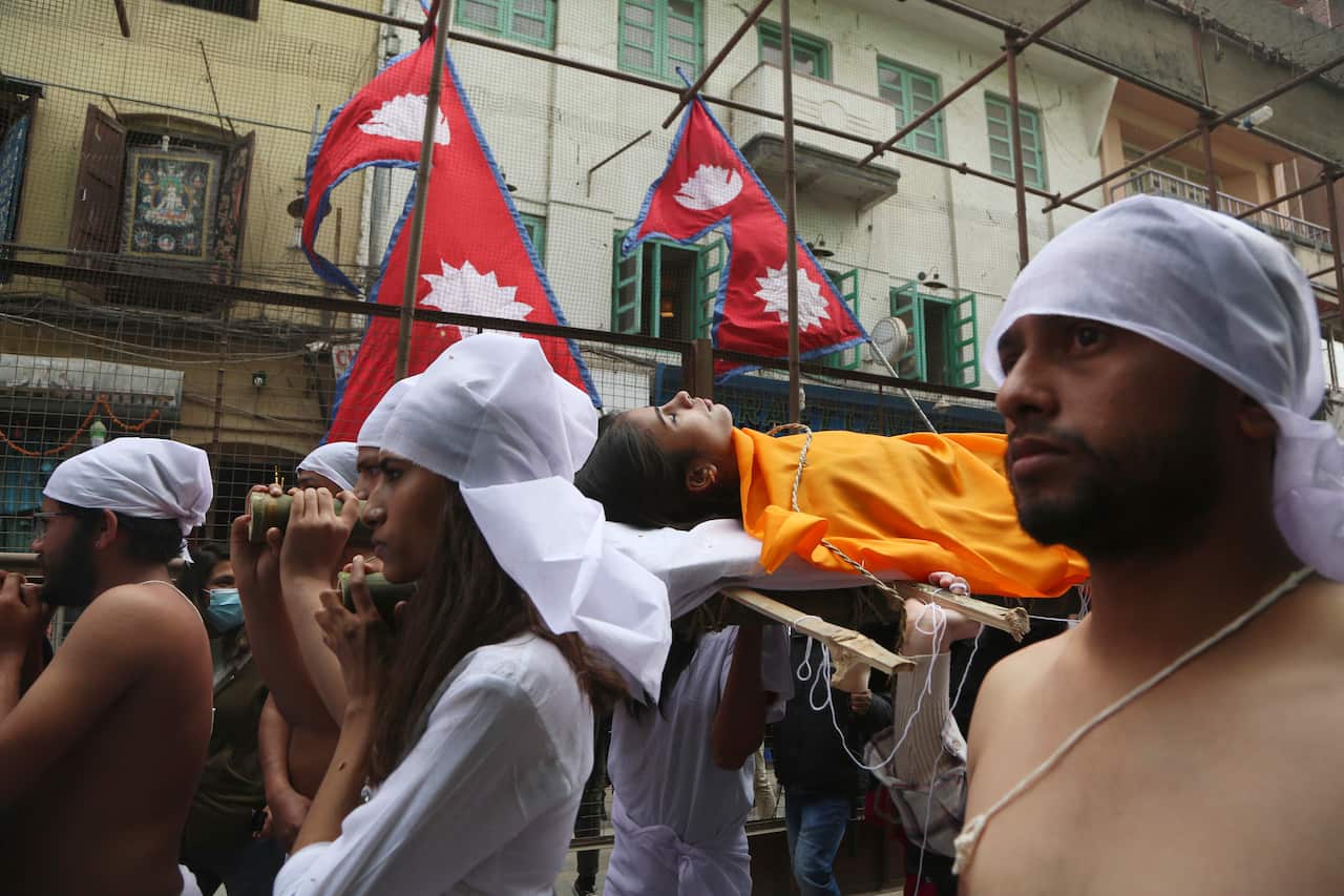 Nepal activists stage a mock Hindu funeral during a protest rally in Kathmandu, Nepal, Friday, Feb. 12, 2021.