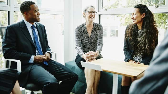 Smiling mature businesswoman leading team meeting