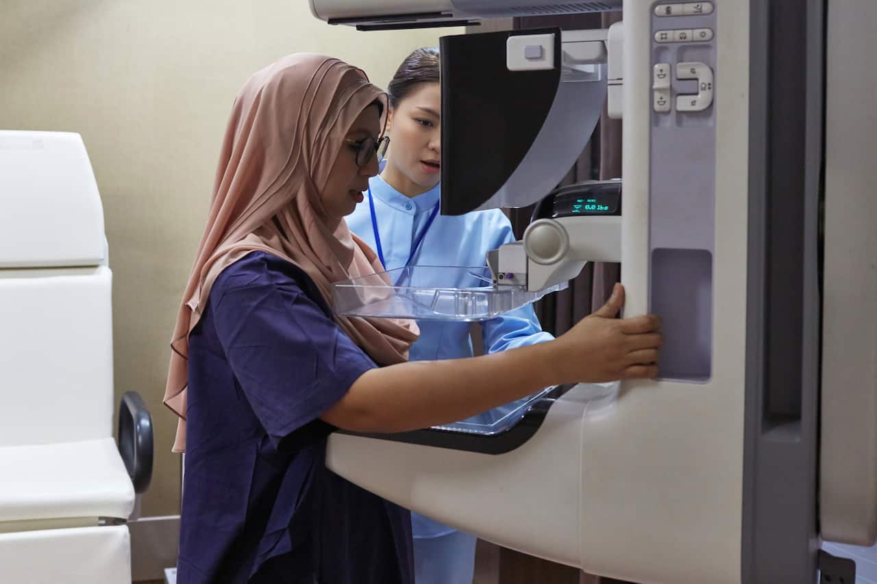 Nurse Assisting Patient During Mammography Exam