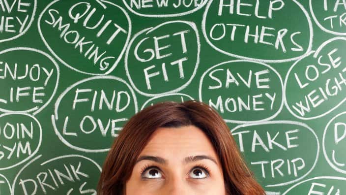 A woman thinking of different New Years resolutions