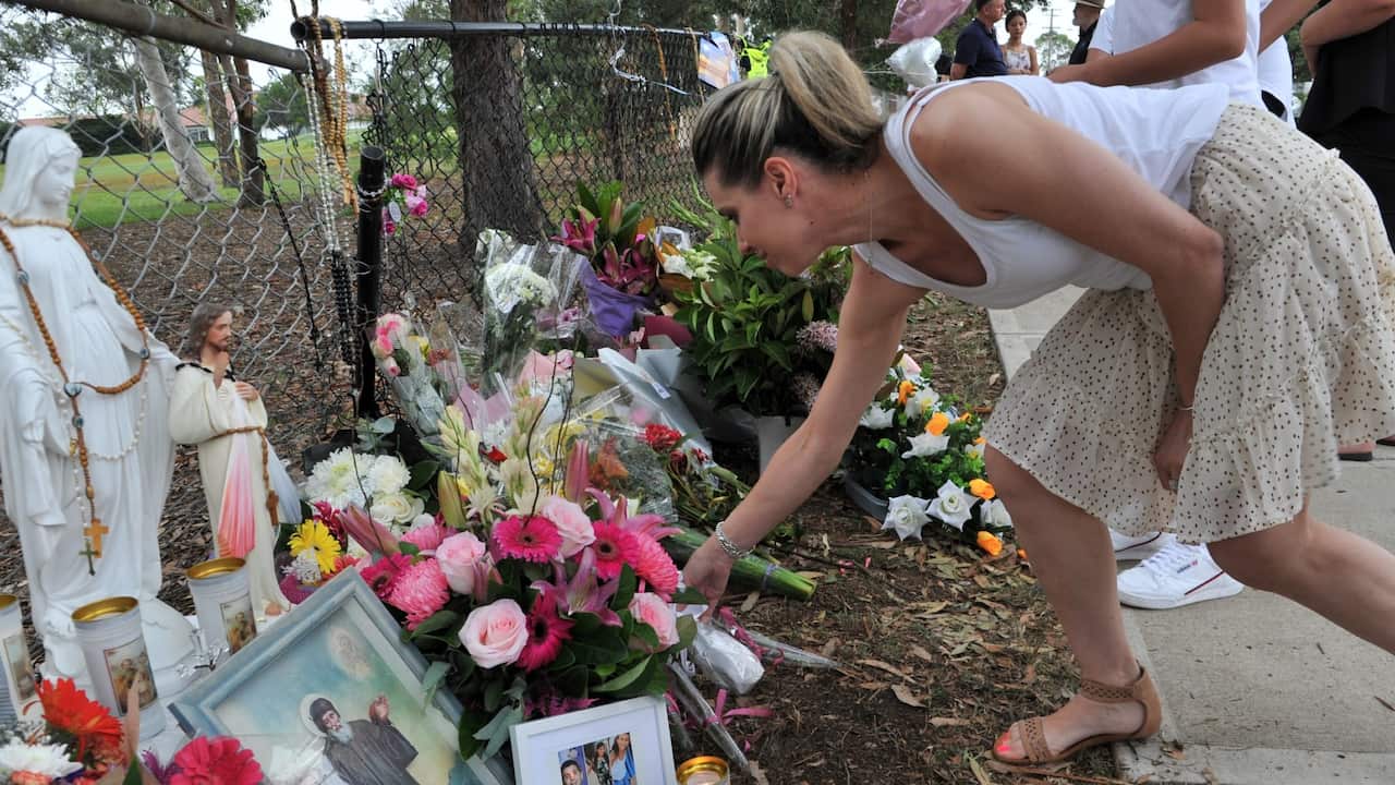 woman paying respects at makeshift memorial in Oatlands, Sydney