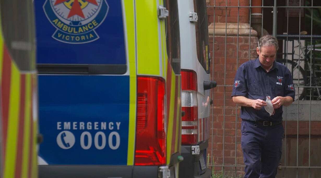 Paramedics are seen tending to their ambulance outside St. Vincent hospital in Melbourne.