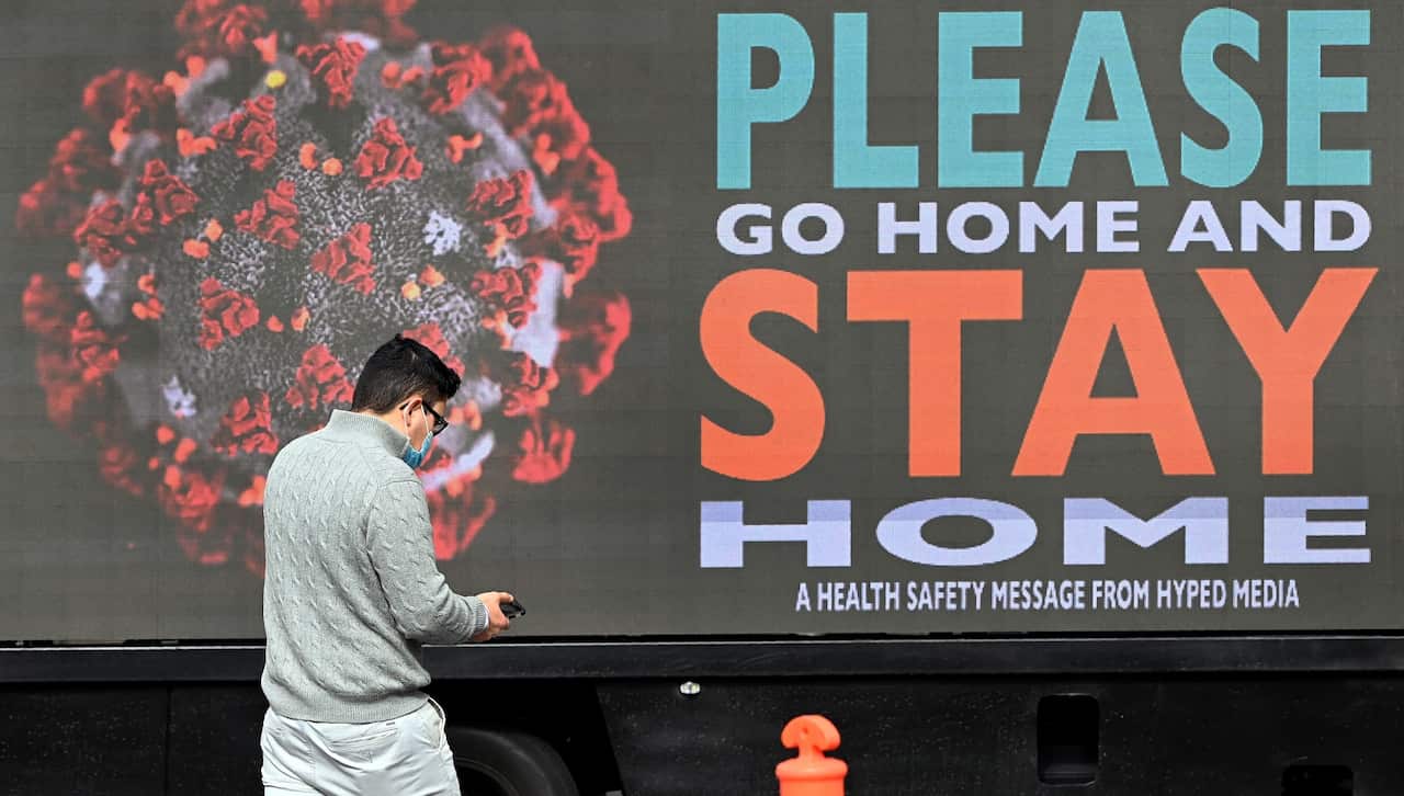 A man walks past a sign on a truck in Melbourne as the city enforces strict lockdown restrictions.