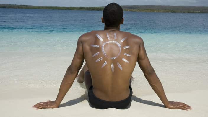 Hispanic man sitting on beach