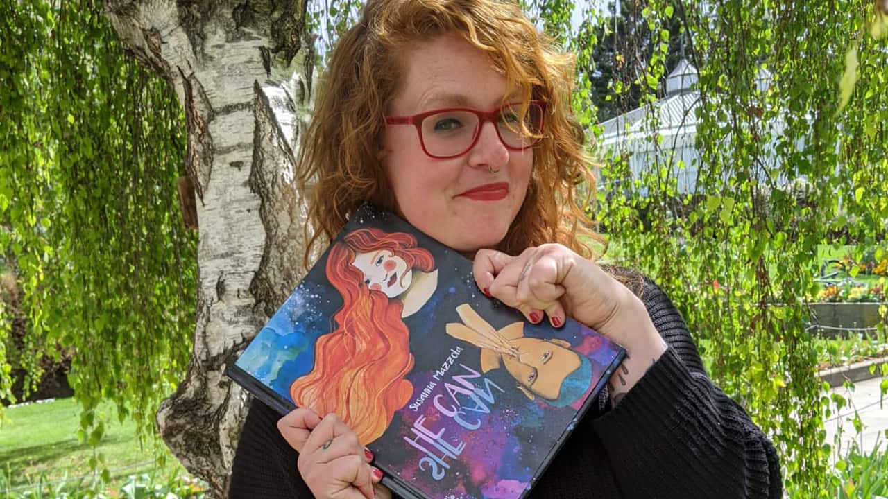 Susanna Mazzola with a copy of her book "HE can SHE can"