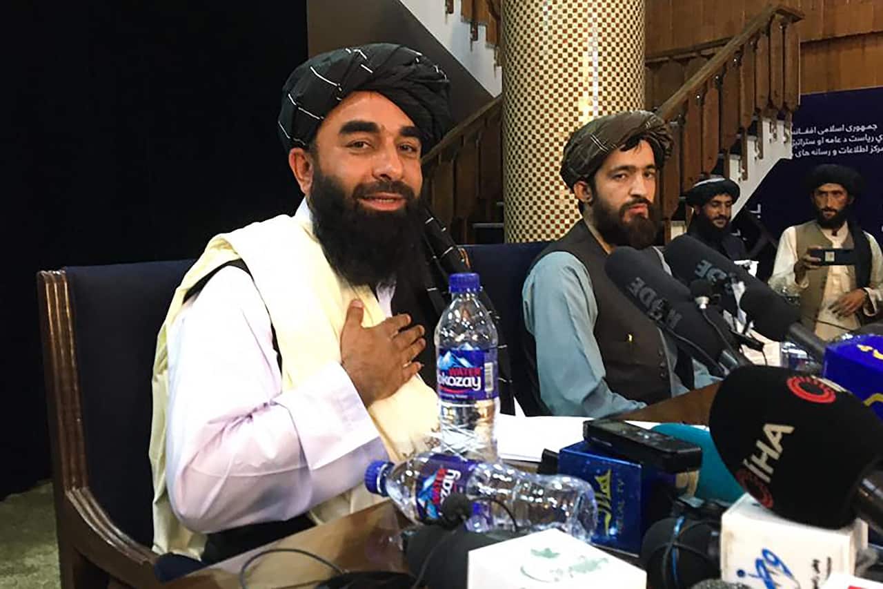Taliban spokesperson Zabihullah Mujahid (L) attends the first press conference in Kabul on August 17, 2021, following their stunning takeover of Afghanistan. (Photo by Hoshang HASHIMI / AFP) (Photo by HOSHANG HASHIMI/AFP via Getty Images)