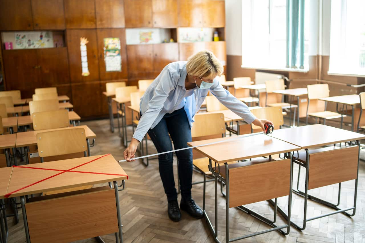 COVID-19. Teacher marks empty places in the classroom