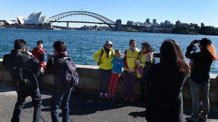 Chinese tourists take in the sites of the Sydney Harbour Bridge and the Sydney Opera House from Mrs Macquarie's Chair in Sydney.