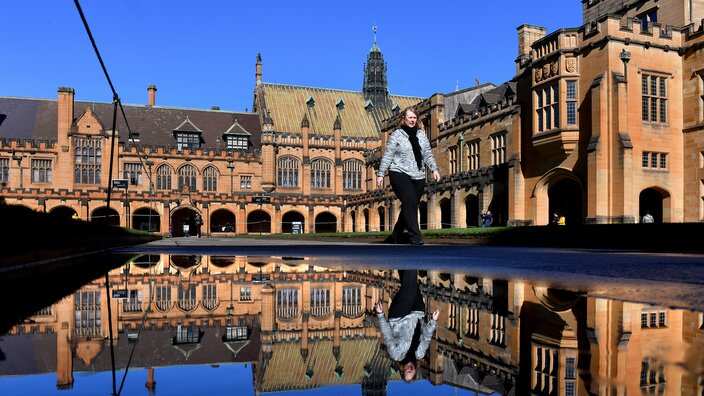 Sydney University quadrangle is seen reflected in a water puddle in Sydney, Thursday, July 6, 2017. (AAP Image/Mick Tsikas) NO ARCHIVING