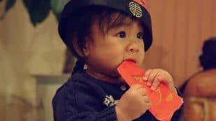 A little girl with a red pocket envelop