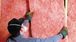 Worker insulating a house