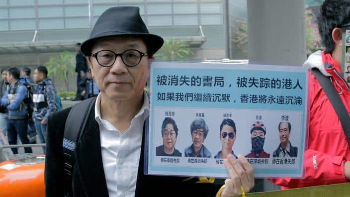A protester holds up a poster of the five Causeway Bay Books staff that disappeared in late 2015