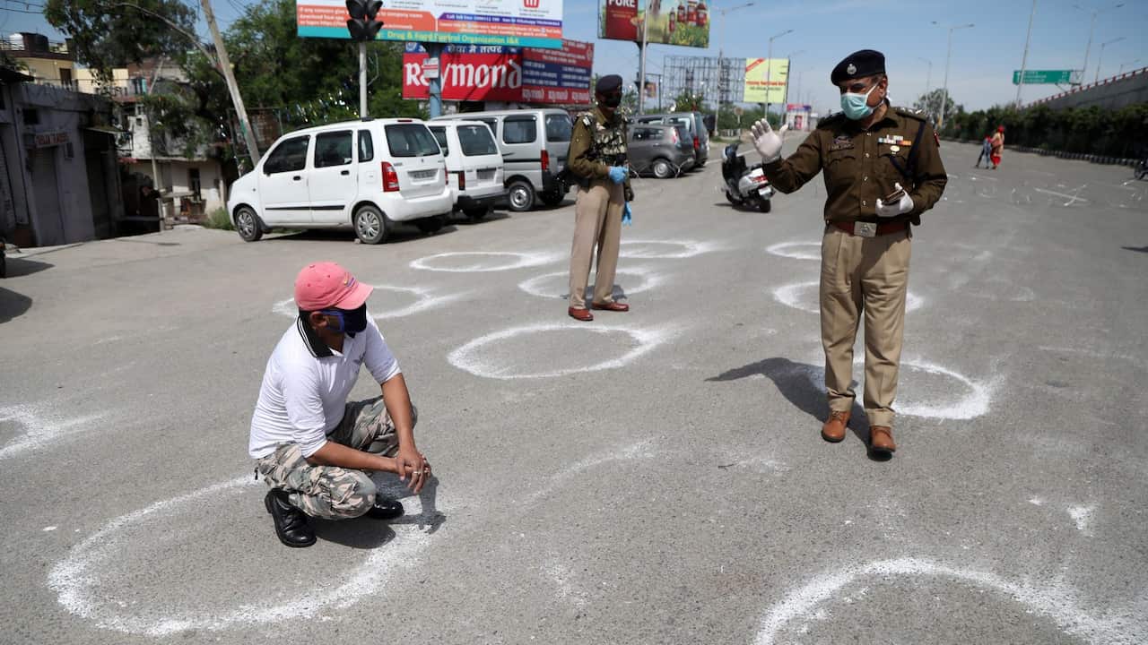 Jammu and Kashmir police officers force man to crouch inside a marked circle to maintain a minimum social distance after he allegedly violated Section 144 (gathering of more than three people) during a government-imposed nationwide lockdown 