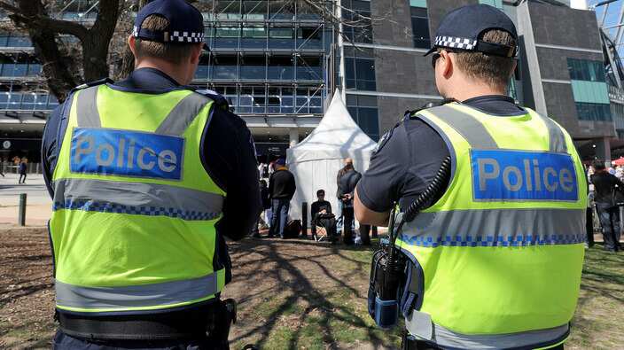 Members of the Victoria Police stand 