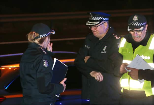 Victoria Police Chief Commissioner Graham Ashton (centre) is seen near where Emergency services responded to a collision in Melbourne.
