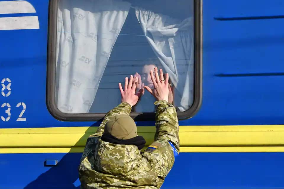 A Ukrainian serviceman says farewell to his wife after she boards an evacuation train departing the Kramatorsk railway station.