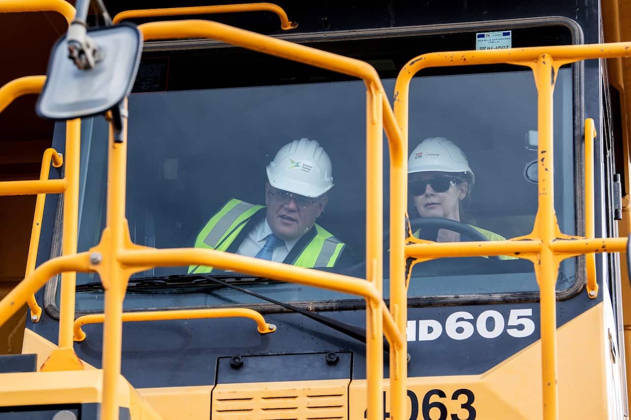 Australian Prime Minister Scott Morrison (left) and truck driver Julie Moore are seen inside a haul truck during a visit to the Western Sydney Airport site in Luddenham, NSW, Monday, March 28, 2022. (AAP Image/Bianca De Marchi) NO ARCHIVING