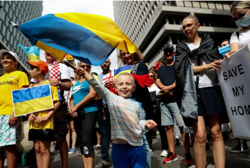 Protesters hold placards and flags during a rally against the war in Ukraine in Sydney, February 27, 2022