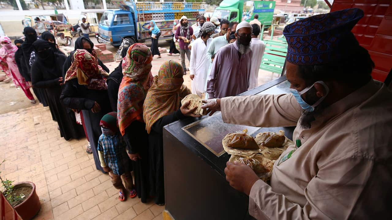 People line up to receive free food distributed by Saylani Welfare Trust during complete lockdown of Sindh province, in Karachi, Pakistan, 26 March 2020.