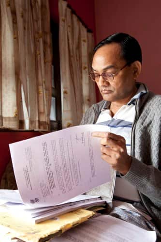 Ramesh Agrawal reviews Right To Information (RTI) documents at his home in Raigarh, India
