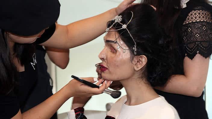 Acid attack survivor Reshma Bano Qureshi has makeup applied before she walks the runway during a rehearsal at New York Fashion Week (Getty)