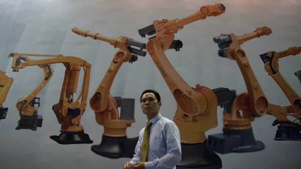 A man walks past a billboard at 2017 China International Robot Show in Shanghai