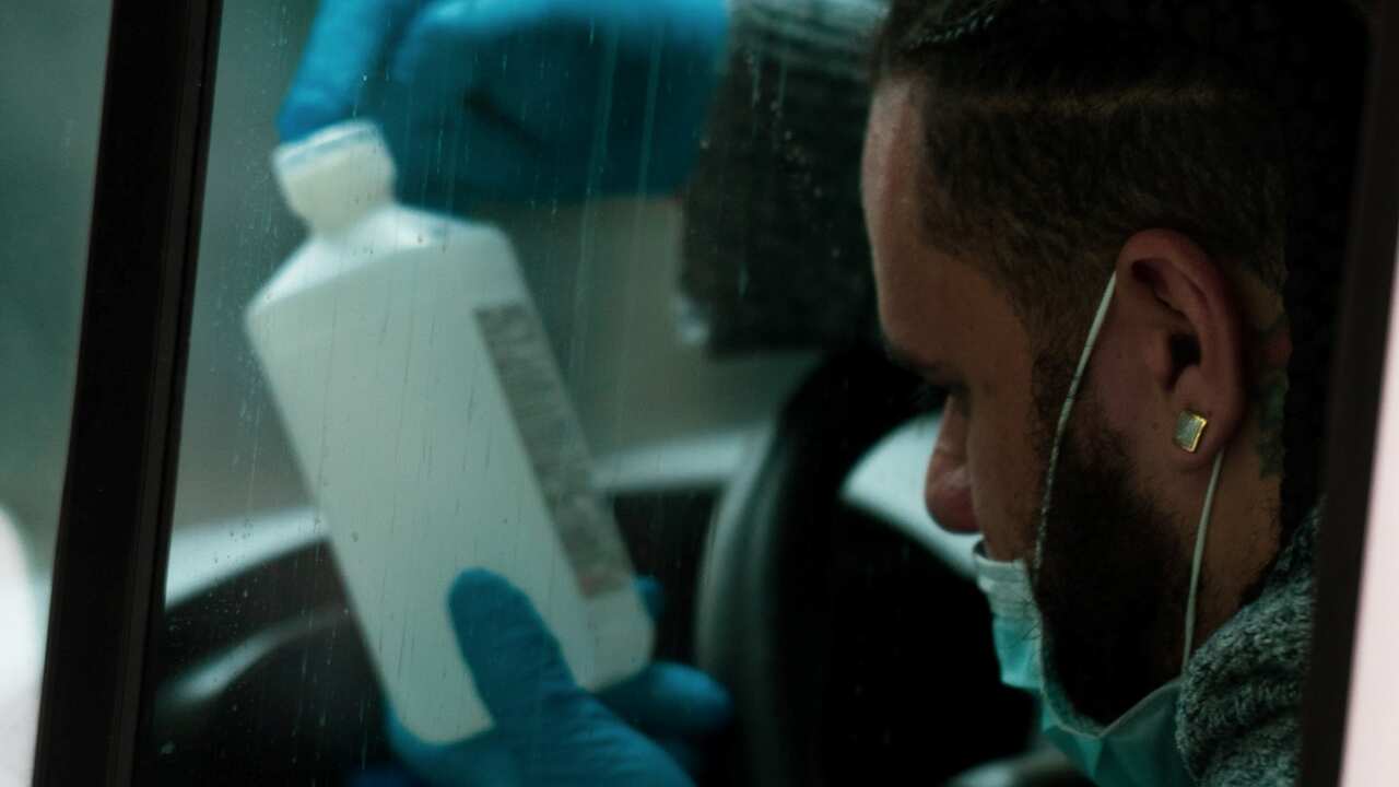 A New York driver is examining a bottle of alcohol.