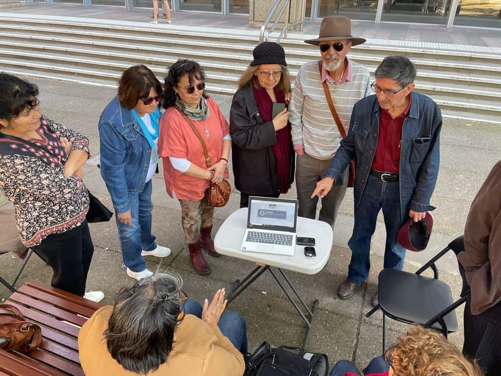 Chilean migrants watch proceedings outside of the court.