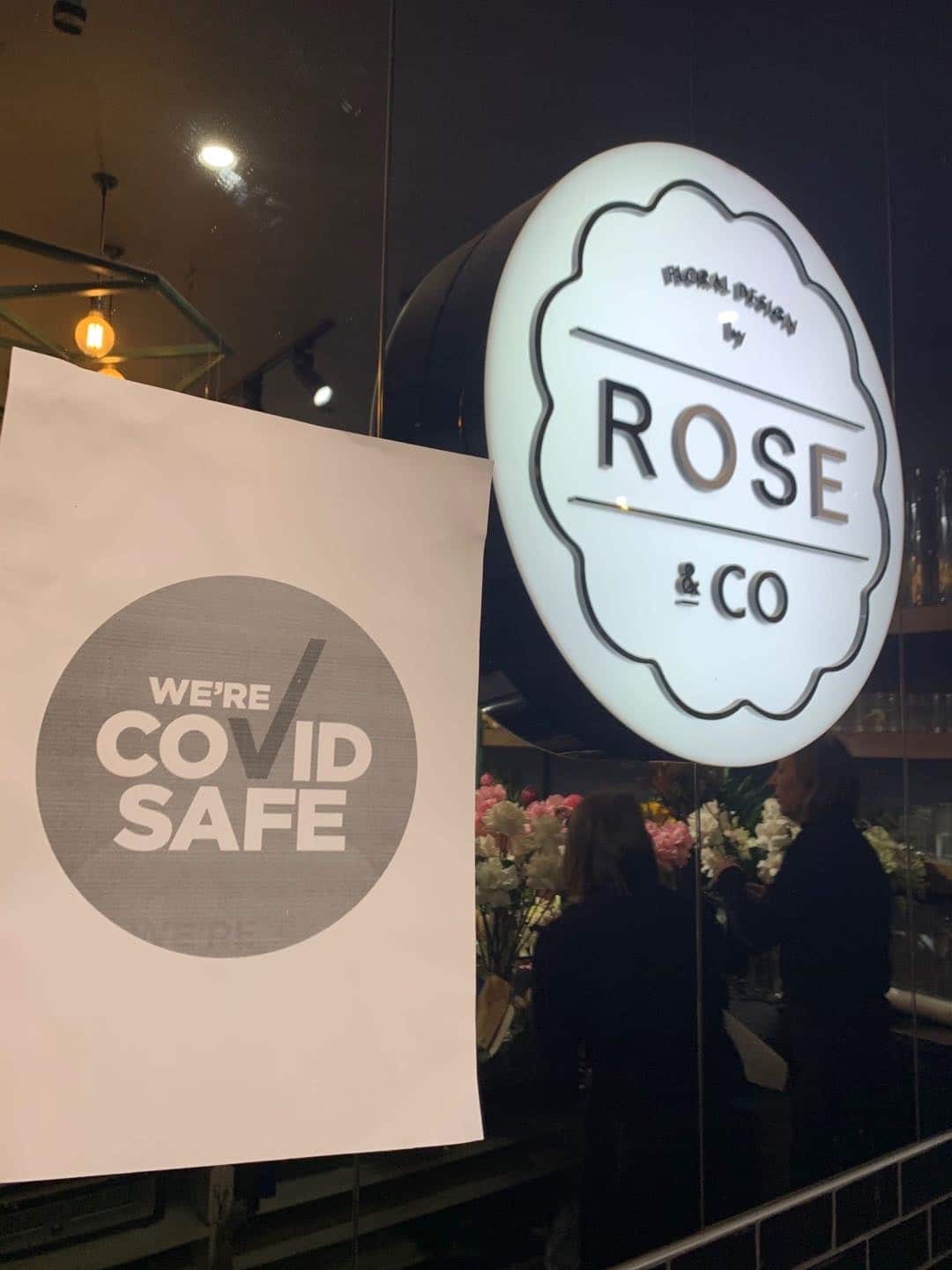 Bango lenye taarifa ya usalama wa COVID kwenye dirisha la duka