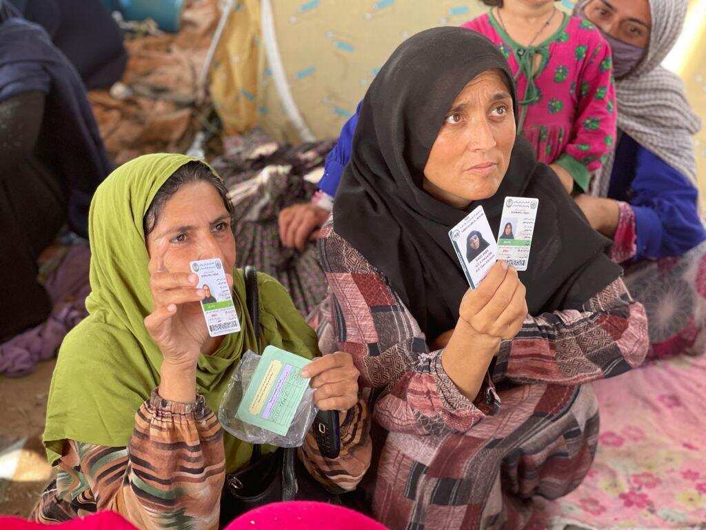Afghan women showing their ID documents. 