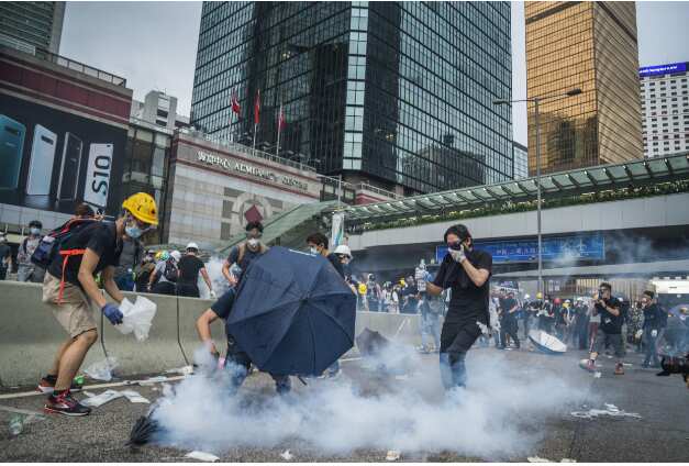 Protester trying to use water to put out the tear gas which the police used against them.