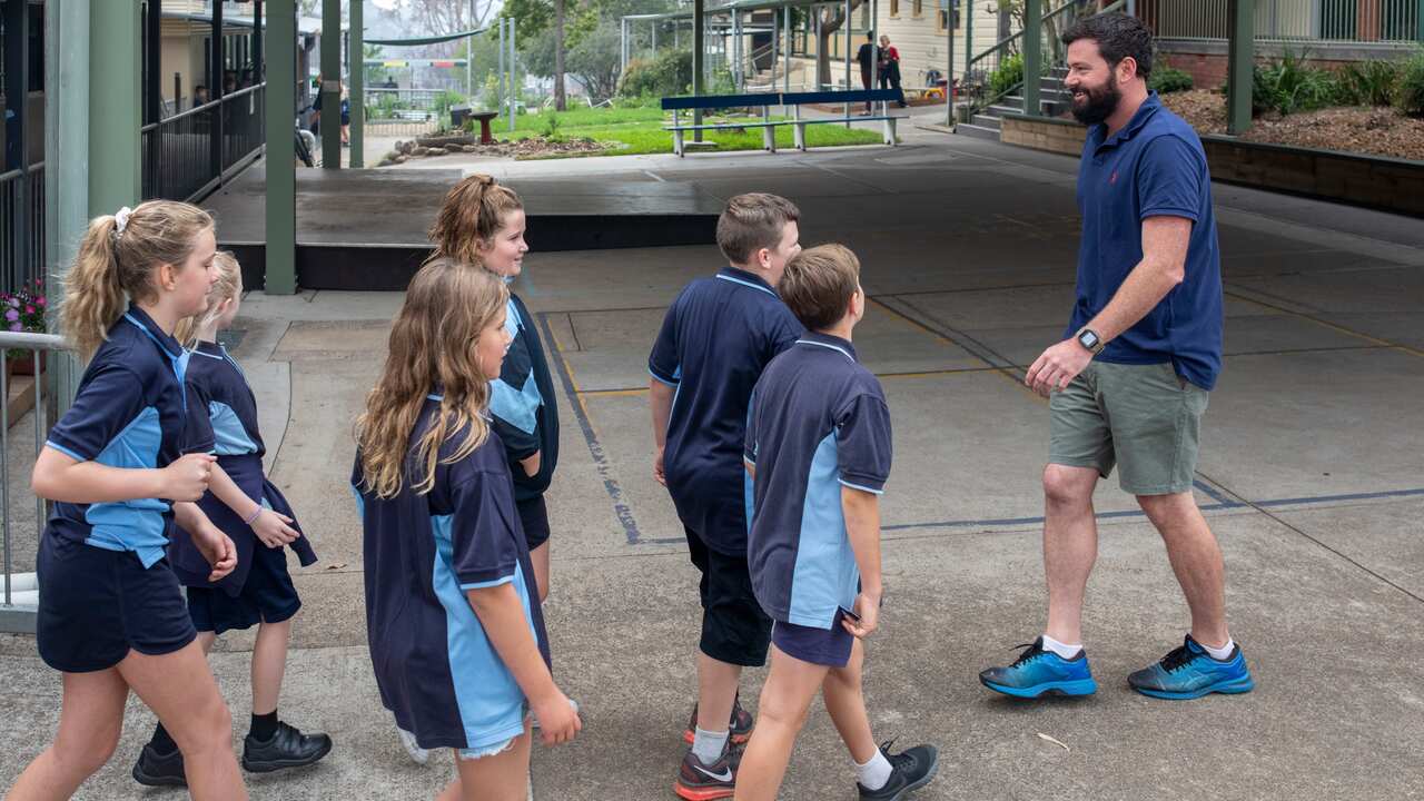 Teacher Campbell Kerr leads his year 5/6 students to assembly on the first day of school in Cobargo, south-east NSW, Wednesday, January 29, 2020. Schools in fire-affected areas resume following a devastating fire season. 