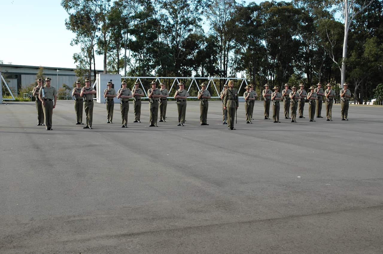 Lieutenant Amrinder Ghuman and 2 Initial Employment Training Troop present arms to the Reviewing Officer.
