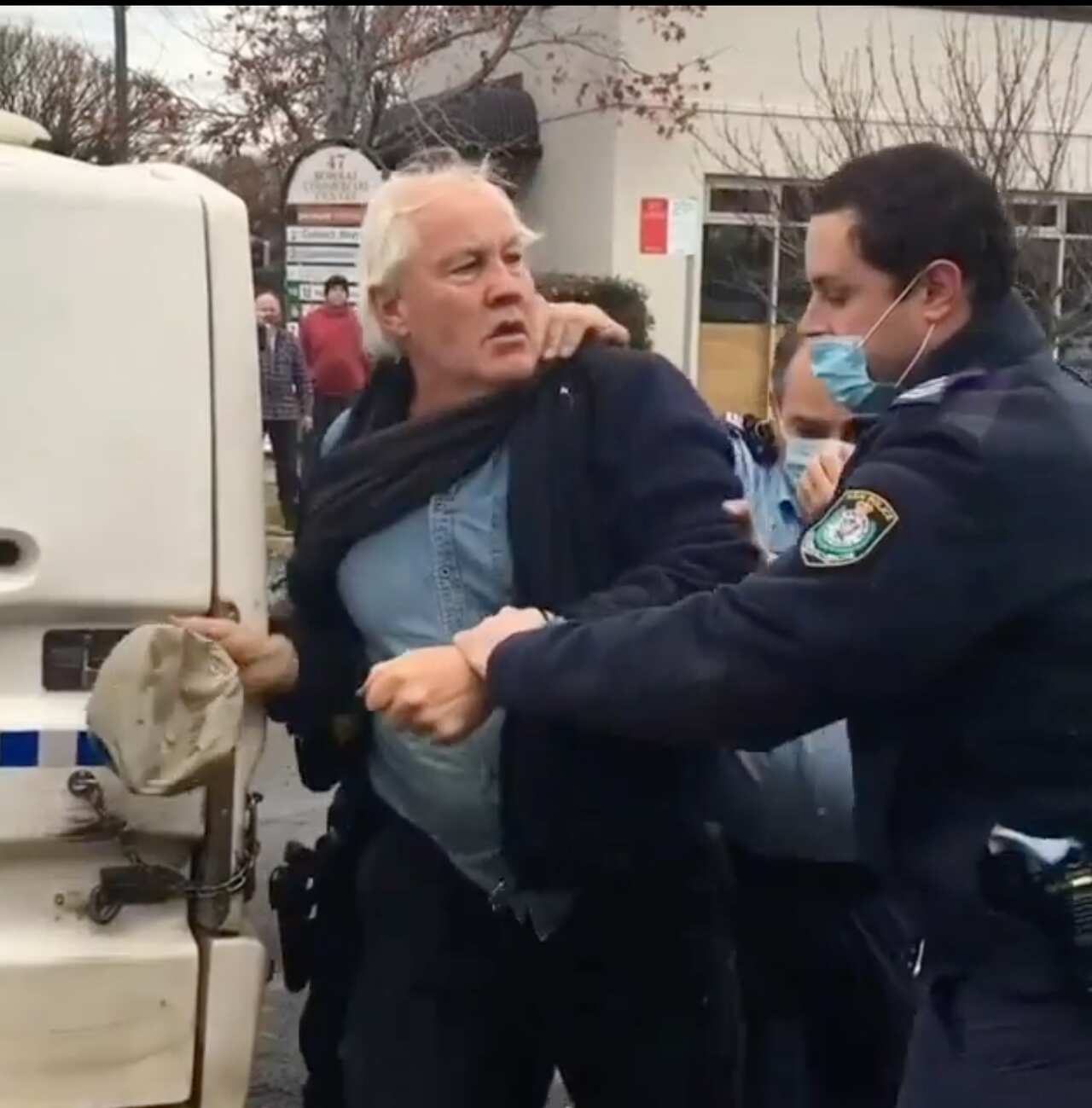 Store owner from Bowral being arrested by NSW police officers for violating mask wearing rules.